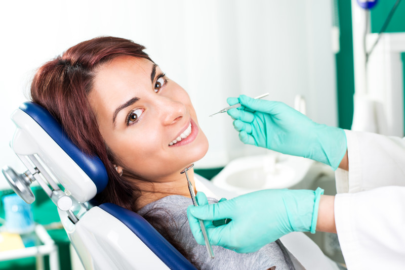 Woman getting her teeth examined by dentist at Dominion Smiles in San Antonio, TX Woman getting her teeth examined by dentist at Dominion Smiles in San Antonio, TX