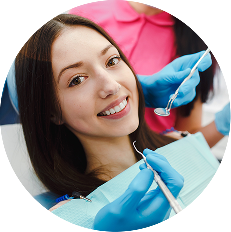 Woman getting teeth cleaned by dental hygienist at Dominion Smiles in San Antonio, TX